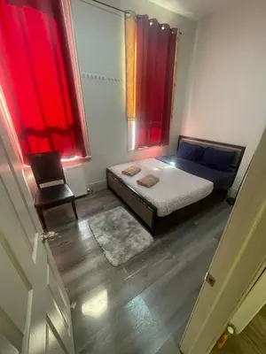 a bedroom with a bed and a window with red curtains at Cost Effective Stay in Core Downtown Queen-King St-Self Checkin & Free Wifi in Toronto
