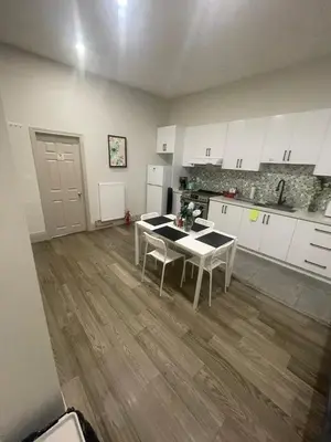 a kitchen with white cabinets and a table with chairs at Cost Effective Stay in Core Downtown Queen-King St-Self Checkin & Free Wifi in Toronto