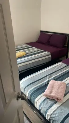 two beds in a room with a door open at Cost Effective Stay in Core Downtown Queen-King St-Self Checkin & Free Wifi in Toronto
