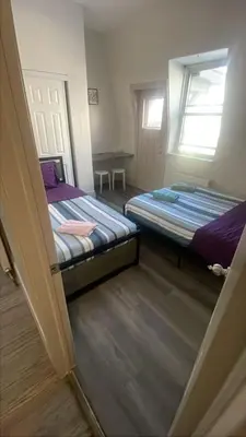 two beds in a small room with a window at Cost Effective Stay in Core Downtown Queen-King St-Self Checkin & Free Wifi in Toronto