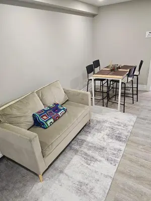 a living room with a couch and a table with chairs at Superb Guest House In Downtown-Self Checkin& Fast Wifi in Toronto