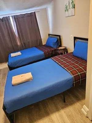 two beds in a room with blue sheets at Superb Guest House In Downtown-Self Checkin& Fast Wifi in Toronto