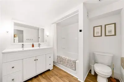a white bathroom with a toilet and a sink at The County Haus - Indoor Pool & Finnish Sauna in West Lake