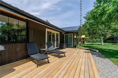 a wooden deck with two chairs and a table at The County Haus - Indoor Pool & Finnish Sauna in West Lake