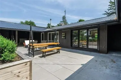 a patio with a wooden table and a bench at The County Haus - Indoor Pool & Finnish Sauna in West Lake