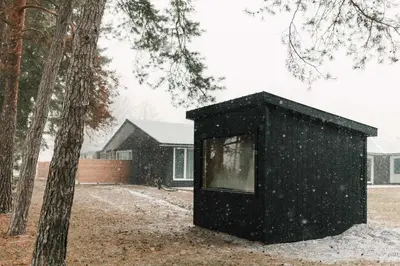 a black box sitting in the snow next to a tree at The County Haus - Indoor Pool & Finnish Sauna in West Lake