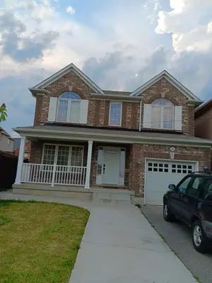 a brick house with a car parked in front of it at House near Toronto Pearson Airport in Brampton