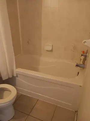 a bathroom with a white tub and a toilet at House near Toronto Pearson Airport in Brampton