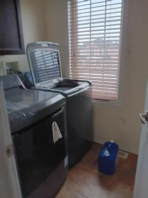 a kitchen with a black dishwasher next to a window at House near Toronto Pearson Airport in Brampton