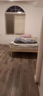 a bed sitting in a room with a window at House near Toronto Pearson Airport in Brampton
