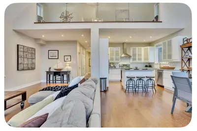 a living room with a couch and a kitchen at Riverside Dreams in Wasaga Beach