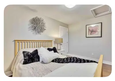a bedroom with a large white bed with pillows at Riverside Dreams in Wasaga Beach