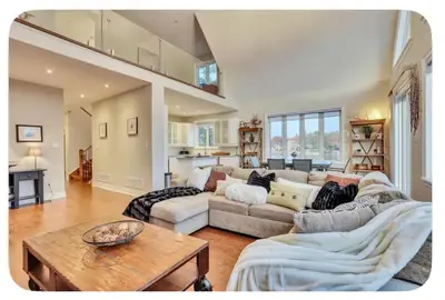 a living room with a couch and a table at Riverside Dreams in Wasaga Beach