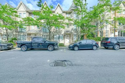 a parking lot with cars parked in front of a building at The Urban Family Pad in Toronto