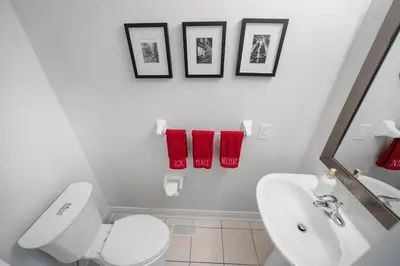 a bathroom with a white toilet and red towels at Spacious Toronto Home Near High Park and Yorkdale Mall in Toronto