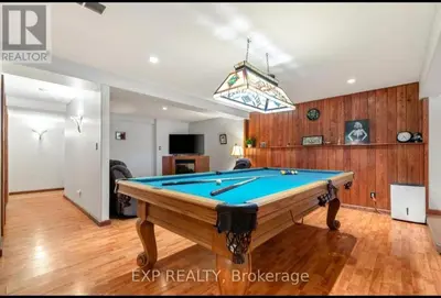 a pool table in a living room with a ceiling at Luxurious home in Belleville in Belleville