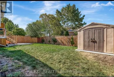 a backyard with a wooden fence and a shed at Luxurious home in Belleville in Belleville