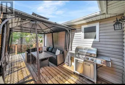 an outdoor patio with a grill and a table at Luxurious home in Belleville in Belleville