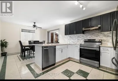 a kitchen with black cabinets and a dining room at Luxurious home in Belleville in Belleville