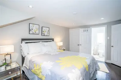 a bedroom with a large bed with a yellow and white blanket at Beautiful 3 bed 2 bathroom home Toronto in Toronto