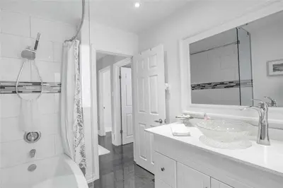 a white bathroom with a sink and a tub and a shower at Beautiful 3 bed 2 bathroom home Toronto in Toronto