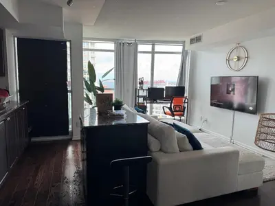 a living room with a white couch and a kitchen at 1 bedroom condo by lakeshore in Toronto