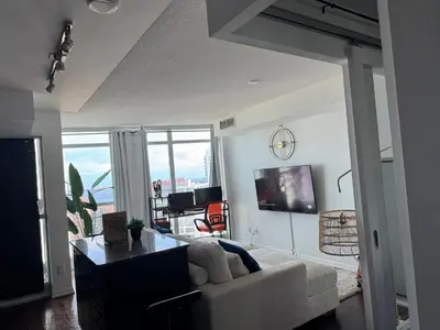 a living room with a white couch and a tv at 1 bedroom condo by lakeshore in Toronto