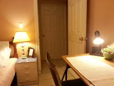 a bedroom with a bed and a table with a lamp at Maria's Homestay in Thornhill