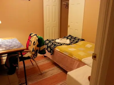 a room with two beds and a table and a table at Maria's Homestay in Thornhill