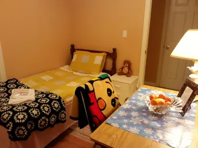 a small bedroom with a bed and a table at Maria's Homestay in Thornhill