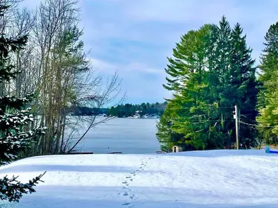 a snow covered yard with a view of a lake at #90 Lakefront 3-bdrm Chalet in Muskoka in Port Carling