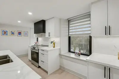 a kitchen with white cabinets and a window at The Wynford Romantic Amalfi Escape in Elora