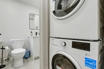 a washer and dryer in a bathroom with a toilet at The Wynford Romantic Amalfi Escape in Elora