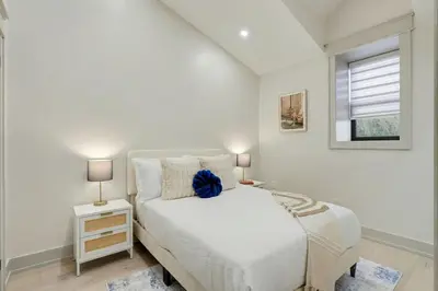 a white bedroom with a bed and a window at The Wynford Romantic Amalfi Escape in Elora