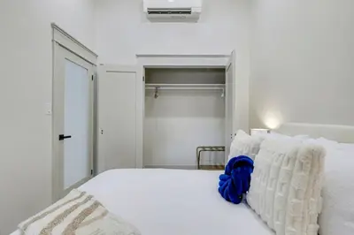 a bedroom with a white bed with a blue bow on it at The Wynford Romantic Amalfi Escape in Elora