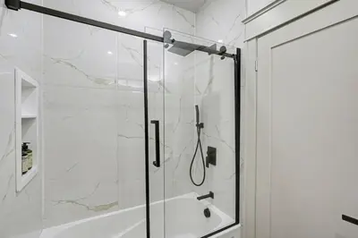a bathroom with a shower with a glass door at The Wynford Romantic Amalfi Escape in Elora