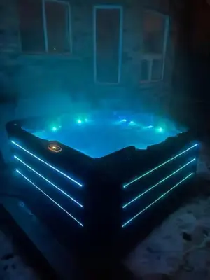 a bath tub with blue lights in the water at Navigate Stays Canada Luxury Hot Tub Retreat Home in Richmond Hill