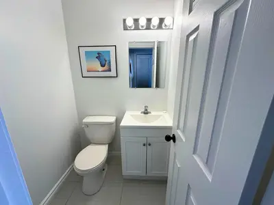 a white bathroom with a toilet and a sink at Family Townhome with outdoor pool access in Collingwood
