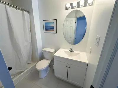 a bathroom with a toilet and a sink and a mirror at Family Townhome with outdoor pool access in Collingwood