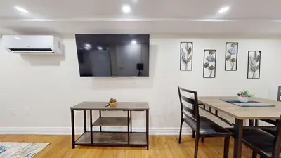 a dining room with a table and chairs and a microwave at Cozy Basement Apartment for 4 - Near Cafes & Parks in Toronto