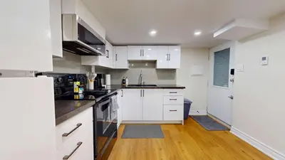 a kitchen with white cabinets and a counter top at Cozy Basement Apartment for 4 - Near Cafes & Parks in Toronto