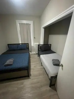 a room with two beds and a door to a bedroom at DOWNTOWN STAY-Free Wifi&Self Checkin in Toronto