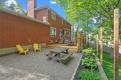 a patio with a wooden table and chairs next to a brick building at 16 Guests Huge Spacious Home Near Ski Resorts in Barrie