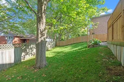 a yard with a fence and a tree at 16 Guests Huge Spacious Home Near Ski Resorts in Barrie