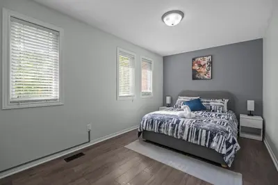 a white bedroom with a bed and two windows at 16 Guests Huge Spacious Home Near Ski Resorts in Barrie