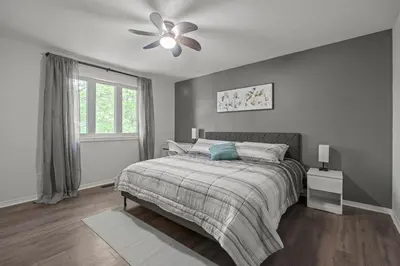 a bedroom with a bed and a ceiling fan at 16 Guests Huge Spacious Home Near Ski Resorts in Barrie