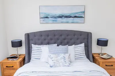 a bedroom with a large bed with two night stands at Sauna, Hot Tub & Heated Pool Blue Mountain Getaway in Blue Mountains
