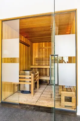 a glass facade of a restaurant with a table and benches at Sauna, Hot Tub & Heated Pool Blue Mountain Getaway in Blue Mountains