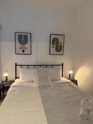 a bedroom with a white bed with two pictures on the wall at Luxury Condo Downtown Toronto in Toronto