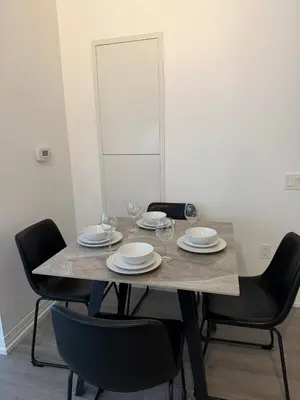 a table with chairs and plates and wine glasses on it at Luxury Condo Downtown Toronto in Toronto